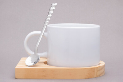 Kleiner Porzellanbecher mit farbigem Henkel